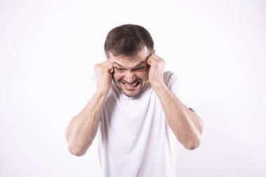 Panik atak geçiren adam. Eller şakaklarda, dişler kenetlenmiş, beyaz arka plan