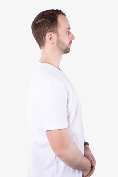 Man stands sideways and looks straight ahead. Arms folded. White background — Stock Photo, Image