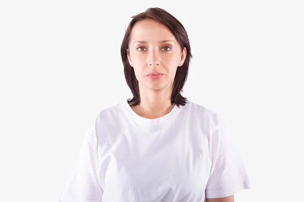 Jeune femme pas de maquillage en t-shirt décontracté regarde calmement. Isolé, fond blanc — Photo