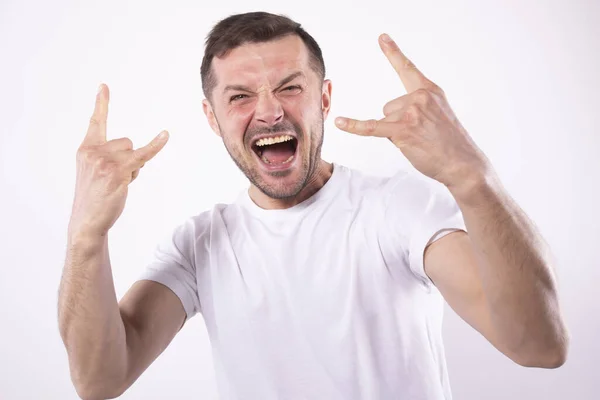 O homem alegra-se com a vitória com um sorriso largo. Mãos na pose de rockon. Conceito de fã de esportes — Fotografia de Stock