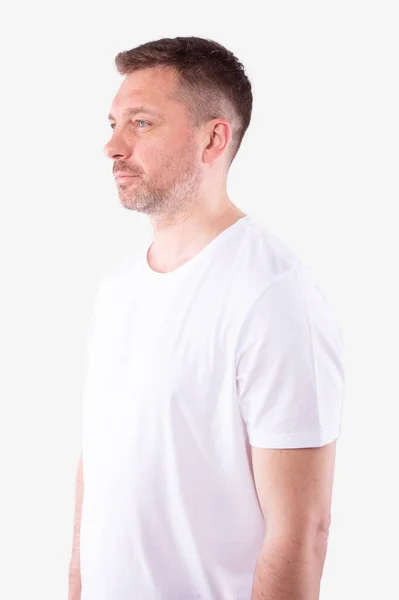 Középkorú, borotválatlan fehér férfi fél oldalt áll, és egyenesen előre néz. — Stock Fotó