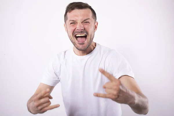 El hombre regocija la victoria con una amplia sonrisa. Manos con cuernos. Concepto de abanico Ardent — Foto de Stock