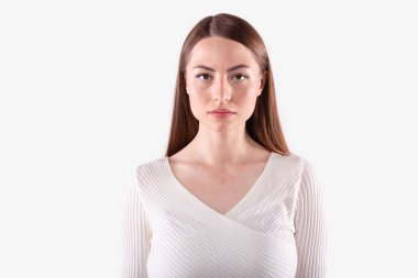 Çekici kadın kameraya ciddi ciddi bakıyor. Beyaz arkaplanda izole.