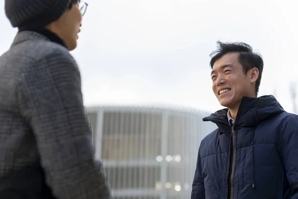 两个有魅力的亚洲男人面带微笑，互相交谈。室外 — 图库照片