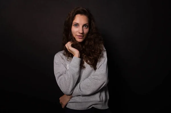 Hermosa chica mirando juguetonamente a la cámara con la mano en el pelo. Concepto de cuidado del cabello — Foto de Stock