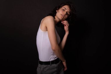 Profesyonel fotoşoplar için poz veren genç bir kadın. Siyah arkaplanda izole