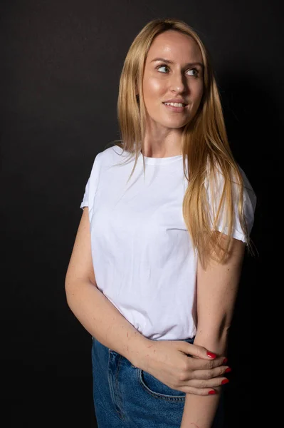 Mujer joven posa con sonrisa mira hacia un lado. Fondo negro. Retrato de personas — Foto de Stock