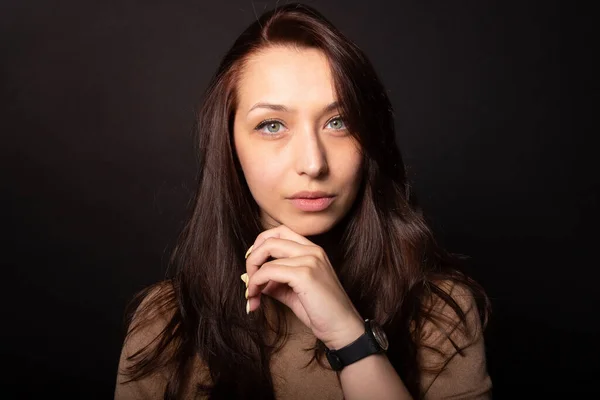 Hermosa chica caucásica con confianza mirando a la cámara. La mano en la barbilla. De cerca. — Foto de Stock