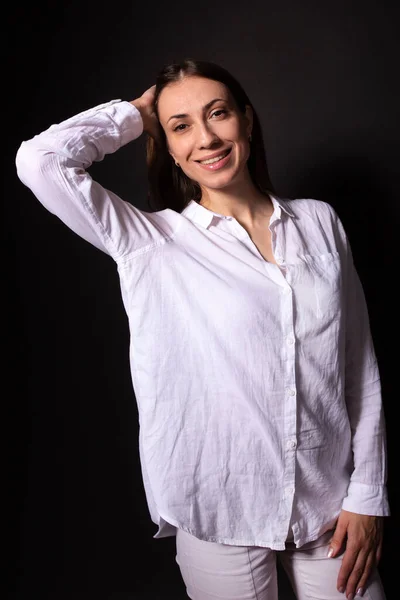 Menina caucasiana de mãos dadas no cabelo, sorrindo e olhando para a câmera. Retrato humano — Fotografia de Stock