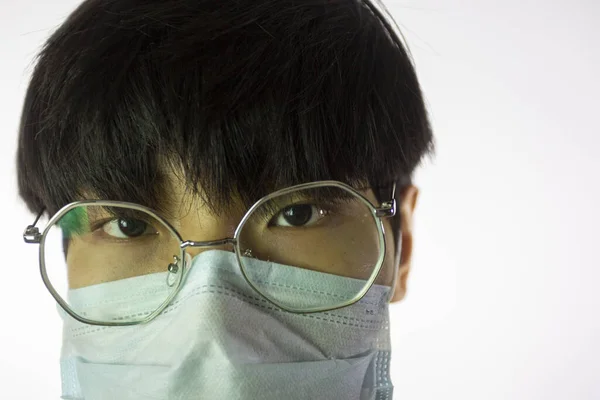 Chino en gafas y máscara quirúrgica contra covid-2019. De cerca. —  Fotos de Stock