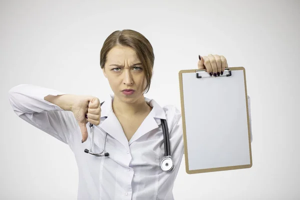 Arrabbiato medico femminile con appunti vuoti che mostrano segno antipatia con i pollici verso il basso — Foto Stock