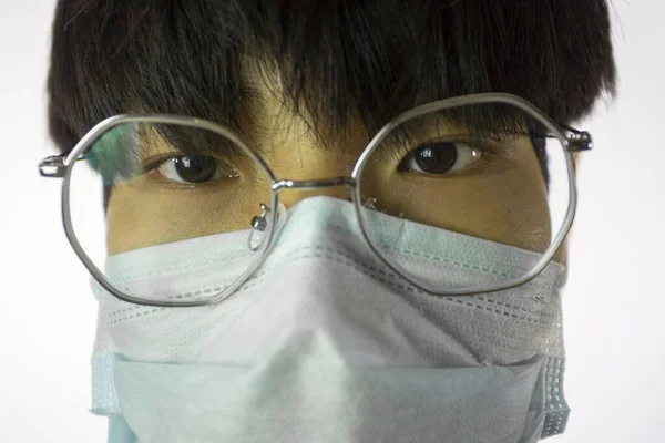 कोविड-19 के खिलाफ चश्मे और मेडिकल मास्क में एशियाई आदमी का चित्र बंद करें — स्टॉक फ़ोटो, इमेज