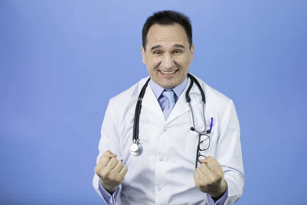 Kaukasischer Erwachsenenarzt auf blauem Hintergrund. Stürmische Freude, ein begeisterter Schrei. — Stockfoto