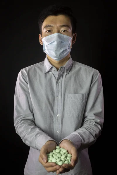 Mannen i medicinsk mask, händerna fulla av mediciner. Utbrott av kinesiskt coronavirus — Stockfoto