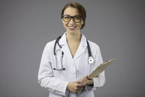 Hermoso médico inteligente en uniforme médico amigable mira a la cámara. Copiar espacio —  Fotos de Stock