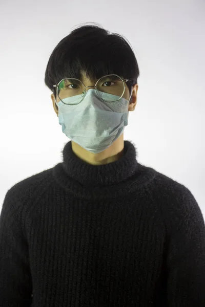Homem chinês jovem em óculos e máscara contra covid-2019. Doença pandémica — Fotografia de Stock