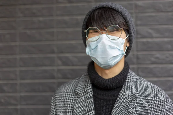 Chinese guy in glasses, facial mask against covid-19 looks tense, upset, angry — Stock Photo, Image