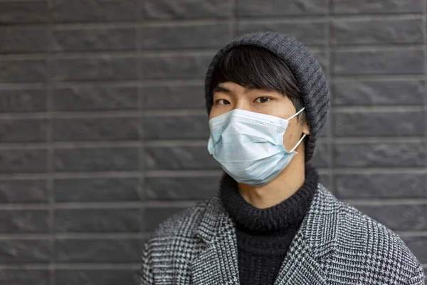 Porträtt av en ung asiatisk man i medicinsk mask. Utbrott av kinesiskt coronavirus — Stockfoto