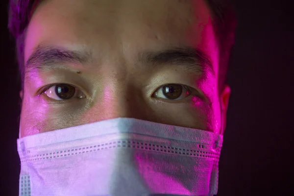 Close up portrait. Asian man in facial mask against 2019-nCov. Black background — Stock Photo, Image