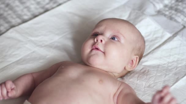 Piccolo bambino neonato carino sul letto sorride, concetto di maternità felice — Video Stock