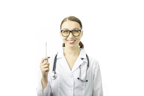 Νεαρή σέξι γυναίκα οδοντίατρος κρατά οδοντόβουρτσα απομονωμένο λευκό φόντο. — Φωτογραφία Αρχείου