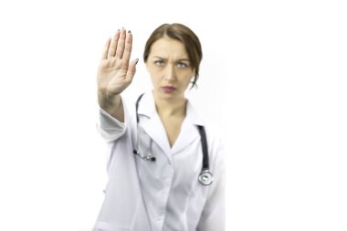 Eli açık güzel bir kadın doktor ciddi bir ifadeyle dur işareti yapıyor.