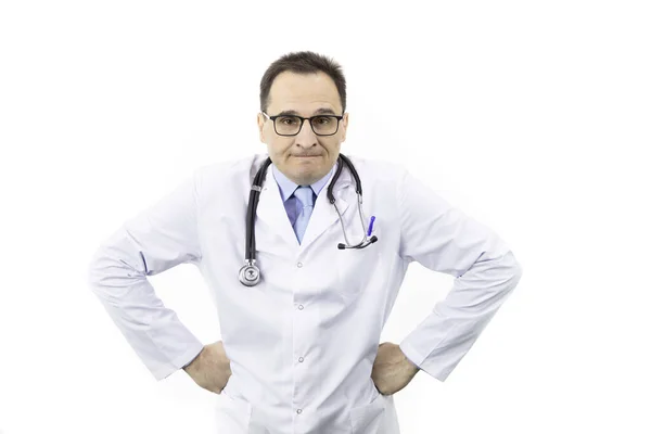 Arzt mittleren Alters blickt mit Wut im Gesicht und den Händen auf der Seite in die Kamera — Stockfoto