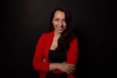 Çekici kız kollarını kavuşturarak geniş bir şekilde gülümser. İş kadını kavramı