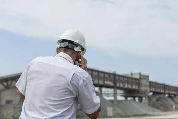 Důlní inženýr v bílé košili a helmě dohlíží na práci žulové dílny — Stock fotografie