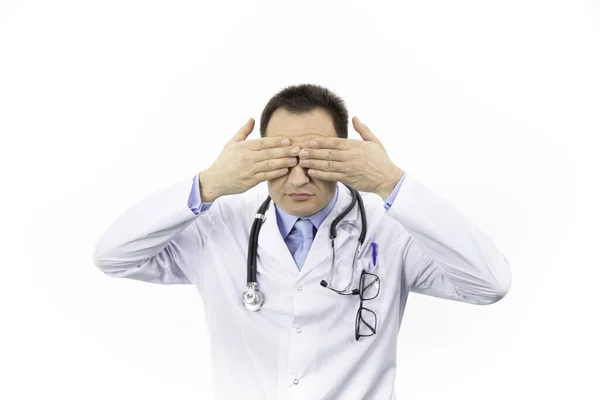 Middle aged doctor in white coat and stethoscope closes eyes with hand, blind — Stock Photo, Image