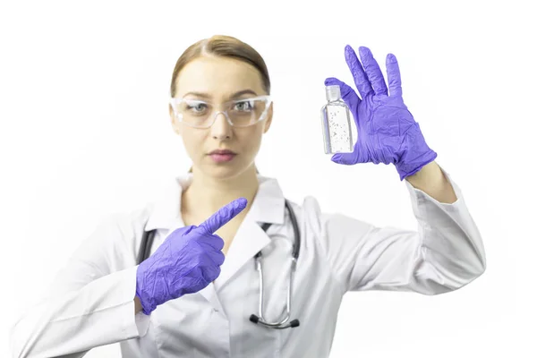Gyönyörű női orvos, aki a fertőtlenítő gélre mutat. Koncentrálj a fertőtlenítőre. Kovid-19 — Stock Fotó