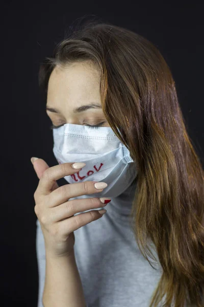 Retrato de mujer asustada de coronavirus en máscara médica con 2019-ncov escrito — Foto de Stock