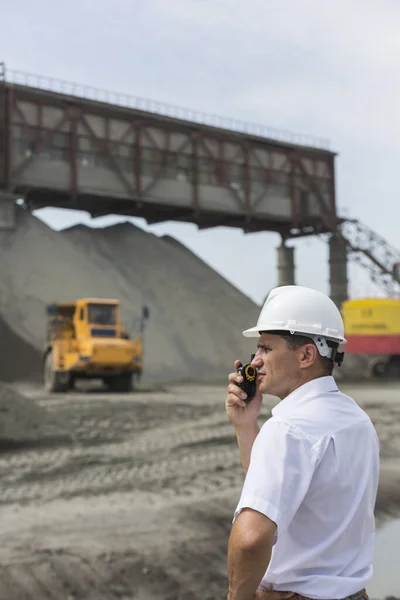 Důlní inženýr dohlíží na práci žulové dílny držící vysílačku — Stock fotografie