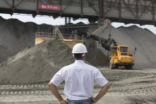 Ingeniero minero en casco supervisa el trabajo de taller de granito — Foto de Stock