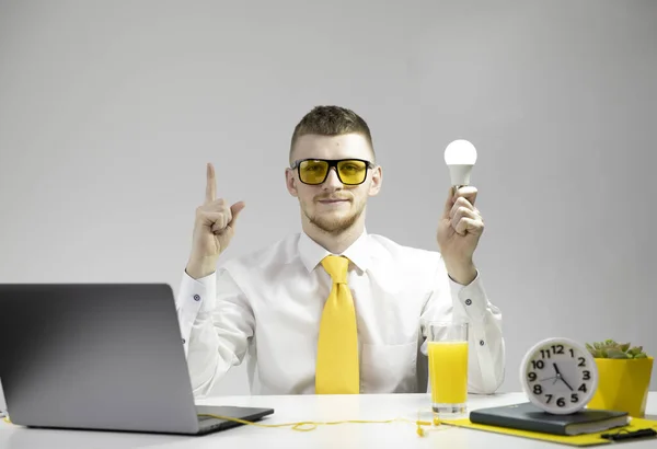 Lindo especialista en camisa, corbata amarilla con lámpara brillante en la mano apunta hacia arriba — Foto de Stock