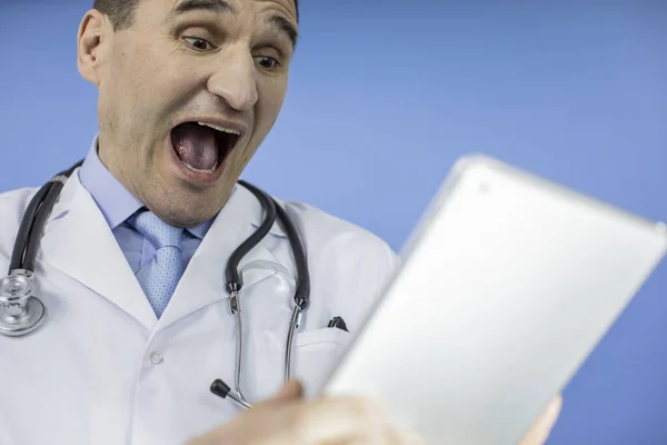 Portrait of an excited adult male physician. Looking at tablet. Close up face — Stock Photo, Image