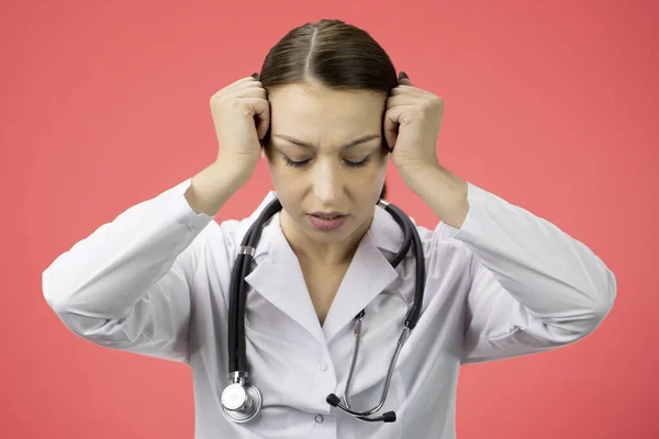 Cansado hermoso médico toma de las manos en las sienes, siente dolor de cabeza, enfermera sobrecargada de trabajo — Foto de Stock