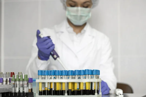 Piękny, skoncentrowany technik laboratoryjny pracuje z próbkami krwi w laboratorium — Zdjęcie stockowe