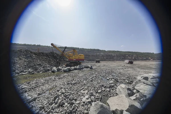 Obří důlní rypadlo nakládající těžké skládkové vozy v žulovém lomu — Stock fotografie