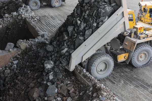 Těžební průmysl těžkých sklápěcích vozů vyložit žulu do obrovské skály drtič horní pohled — Stock fotografie