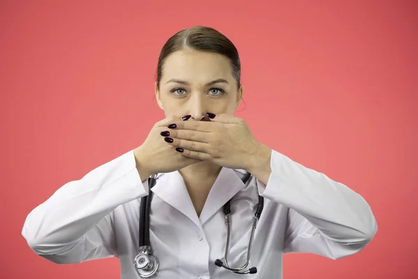 Szexi orvos becsukja száját kézzel, komolyan néz kamera, csend koncepció — Stock Fotó