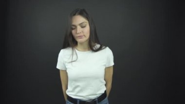 Uzun, gevşek saçlı çekici kız ayakta duruyor ve gülümsüyor.