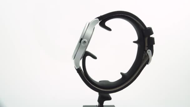 Ібах, Швейцарія 7.04.2020 - Вікторінокс Людина дивиться на сірий годинник з нержавіючої сталі, який обертається на стенді, ізольованому на білому тлі. — стокове відео