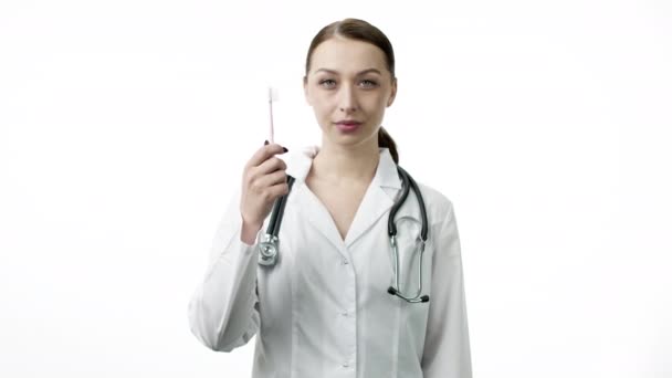 Χαμογελώντας σέξι γιατρός κρατά οδοντόβουρτσα και δείχνει σαν σημάδι με τον αντίχειρα επάνω — Αρχείο Βίντεο
