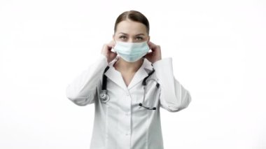 Tıp üniformalı genç ve güzel laboratuvar teknisyeni koruyucu maske taktı.
