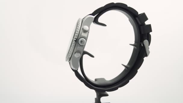 Ібах, Швейцарія 7.04.2020 - Вікторінокс Людина дивиться на чорний годинник з нержавіючої сталі на циферблаті гумовий ремінь, що обертається на стенді ізольований на білому тлі — стокове відео