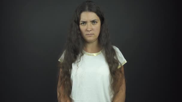 Серьезная женщина в футболке позирует для фотосессии в студии — стоковое видео