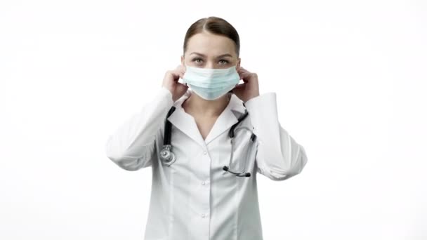 Joven y hermoso técnico de laboratorio en uniforme médico ponerse máscara protectora — Vídeo de stock