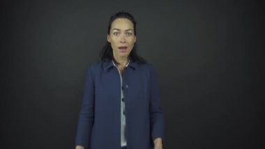 Güzel esmer kadın, şaşkın bir şekilde yüzüne dokunuyor.