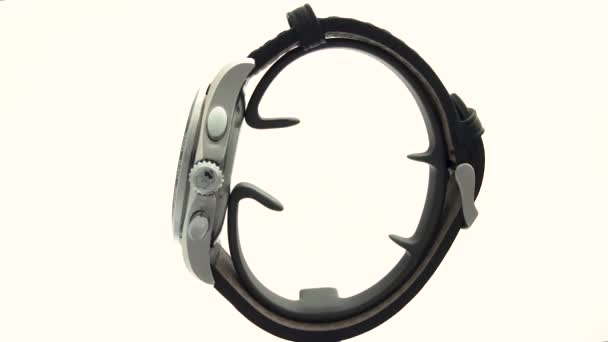 Ібах, Швейцарія 7.04.2020 - Вікторінокс Людина спостерігає за чорним годинником з нержавіючої сталі, який обертається на стенді, ізольованому на білому тлі. — стокове відео